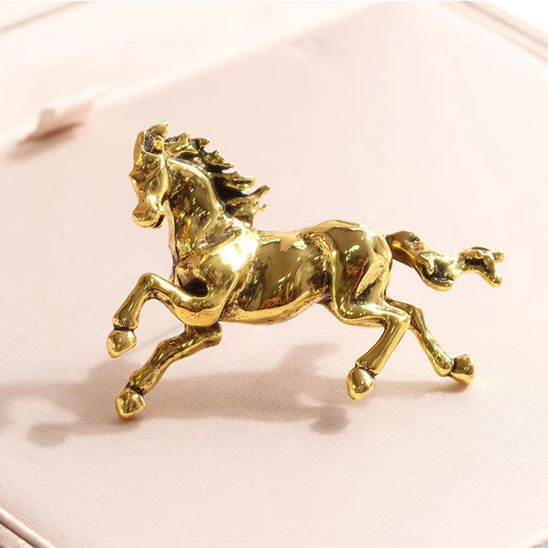 Vintage horse brooch in antique gold on display