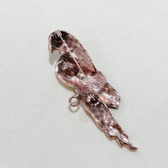 Close-up of the vibrant red parrot brooch