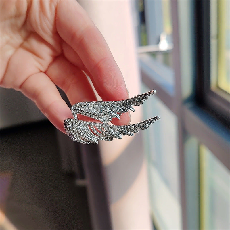 Elegant angel wings brooch displayed on stylish outfit