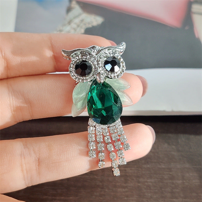Colourful owl brooch with rhinestones on display