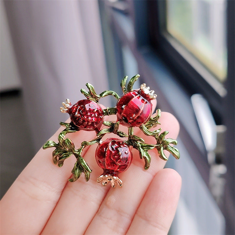 Women wearing a vibrant fruit brooch