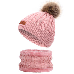 Knit hat and scarf set laid out on a snowy background