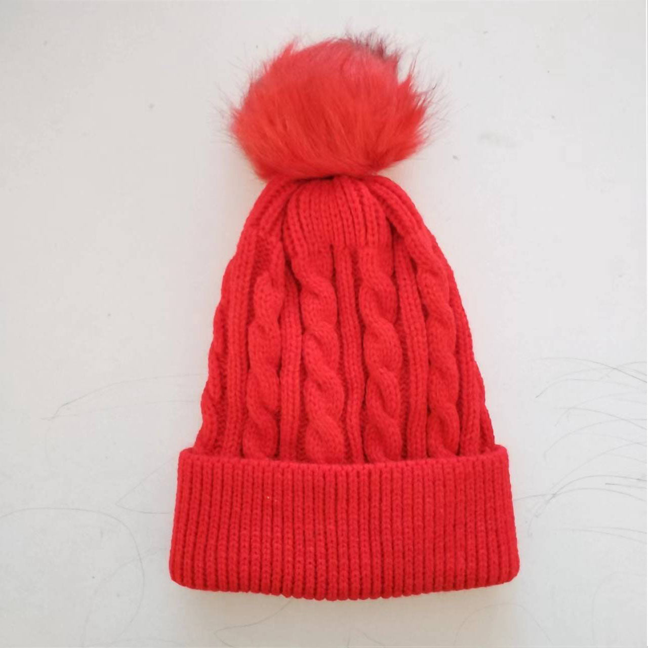 Red knit beanie hat with trendy pom pom