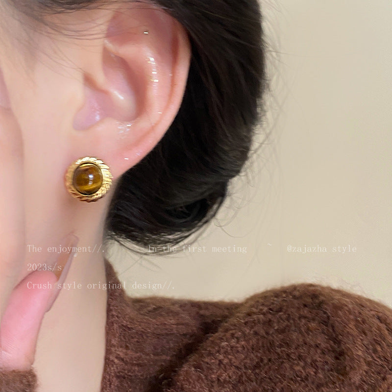 Close up of elegant metal earrings with tiger eye stones