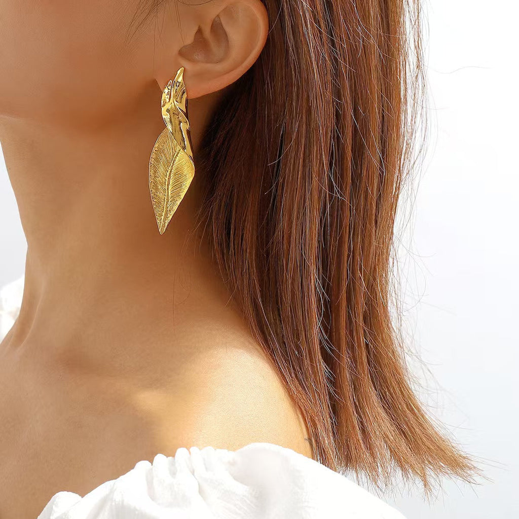 Elegant woman accessorising with leaf earrings