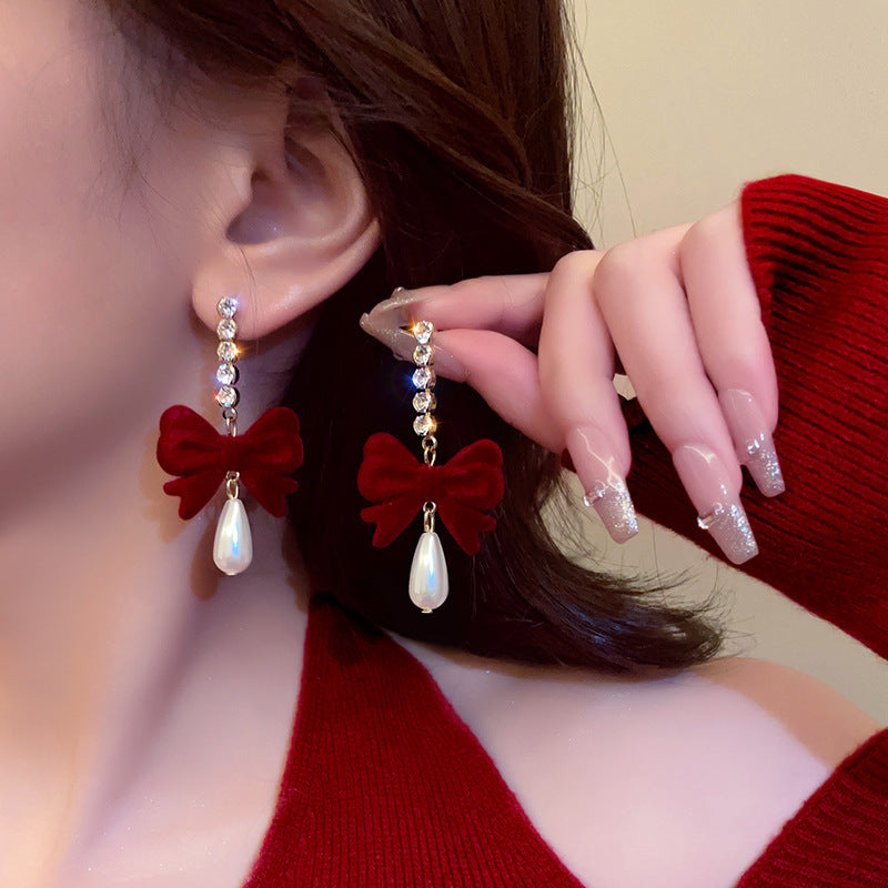 Close up of stylish burgundy bow earrings