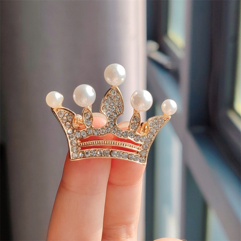 Golden crown brooch showcasing rhinestones